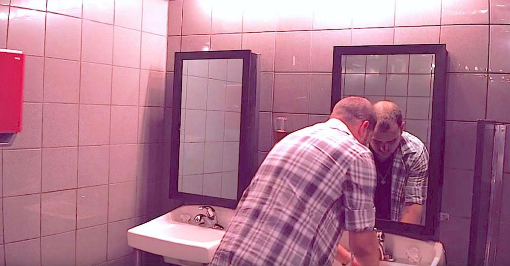 He’s Washing His Hands in a Nightclub Bathroom – Now Pay Attention to the Mirror